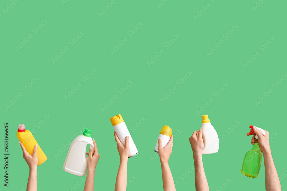 Women with cleaning supplies on green background