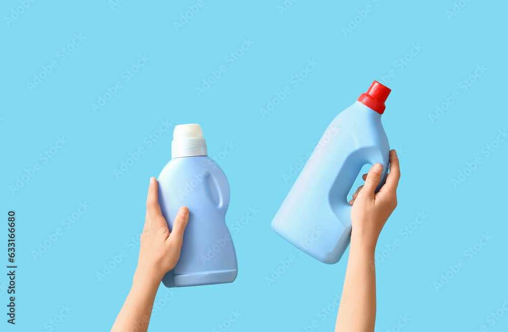 Woman with bottles of detergent on blue background