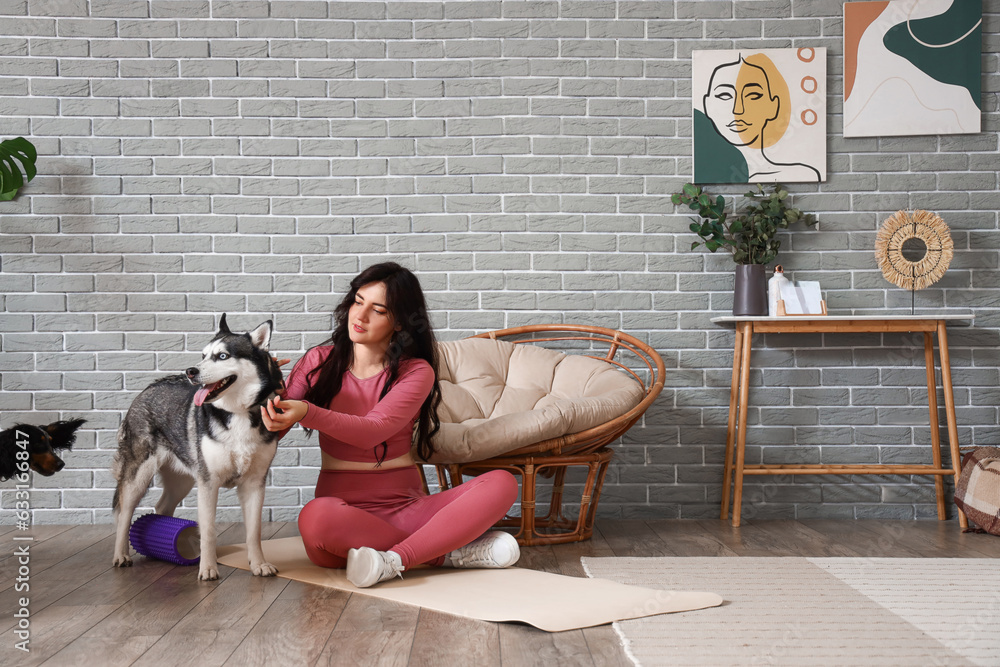 Sporty young woman with her dogs training at home