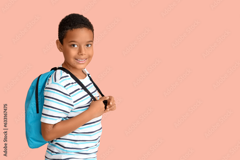 Little African-American boy with school backpack on pink background