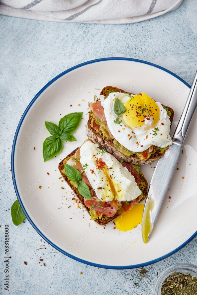 Plate of tasty sandwiches with egg on grey background