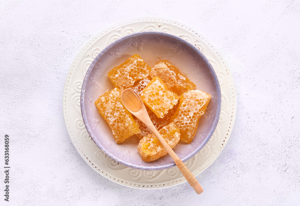 Bowl with sweet honeycombs on white background