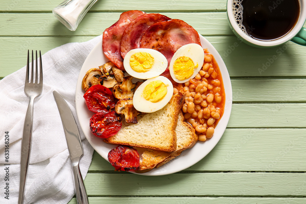 Plate with tasty English breakfast and cup of coffee on green wooden background