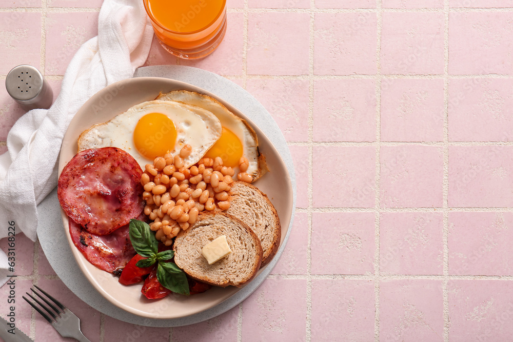 Plate with tasty English breakfast and glass of juice on pink tile background