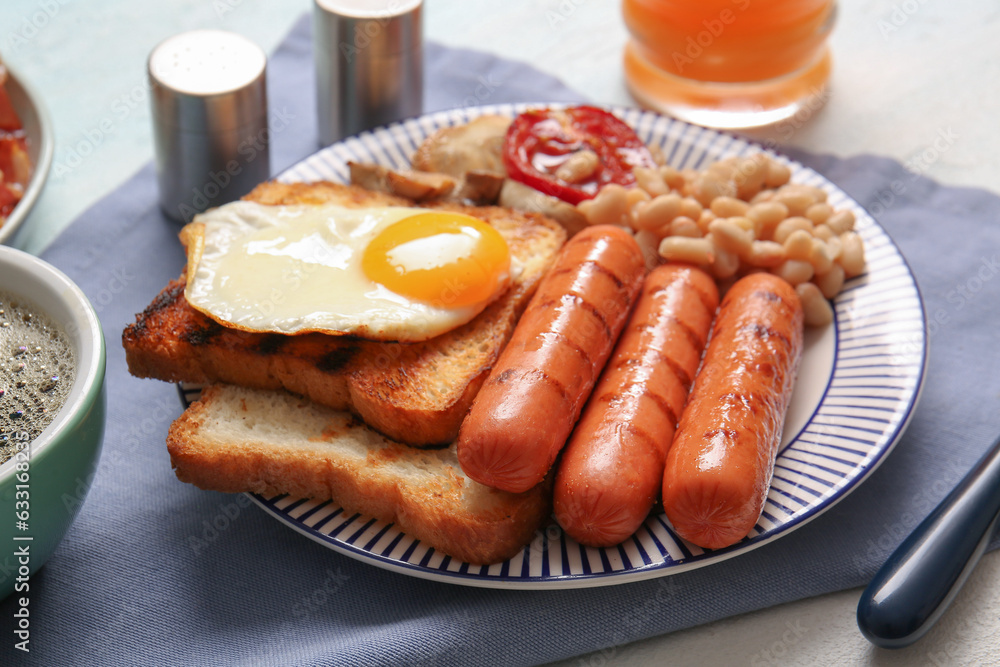 Plate of tasty English breakfast with fried egg on table