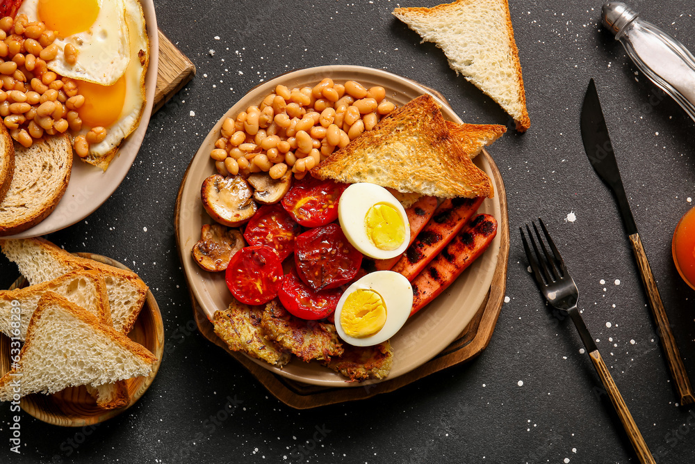 Plates of tasty English breakfast with eggs on black background