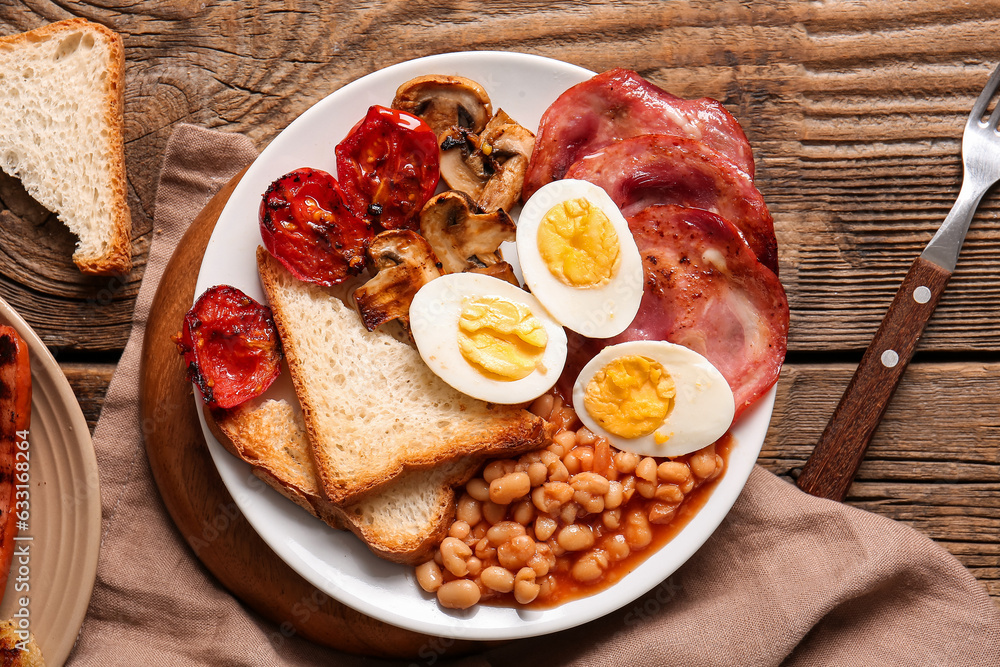 Plate of tasty English breakfast with boiled eggs on wooden background