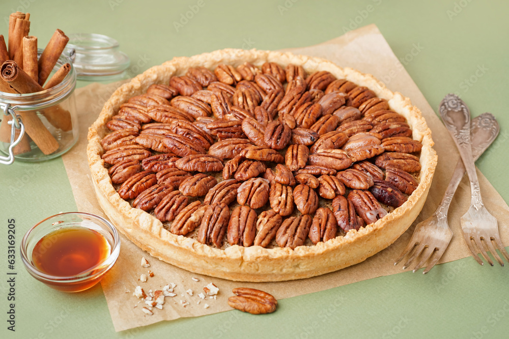 Tasty pecan pie on green background