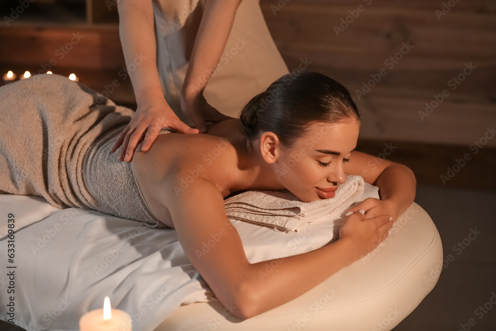 Pretty young woman having massage in spa salon