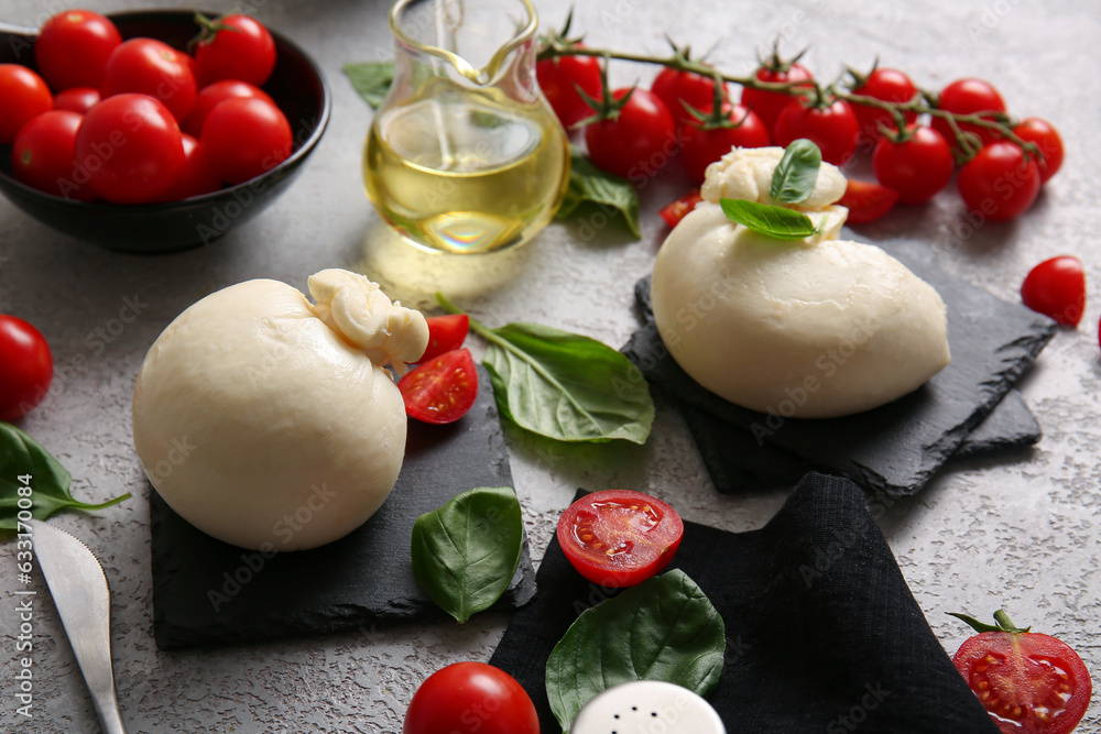 Tasty Burrata cheese with basil and tomatoes on grey table