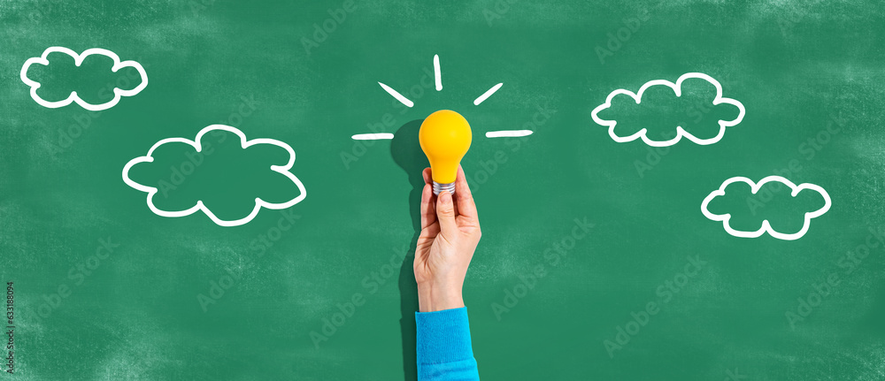 Person holding a yellow light bulb with cloud sketches