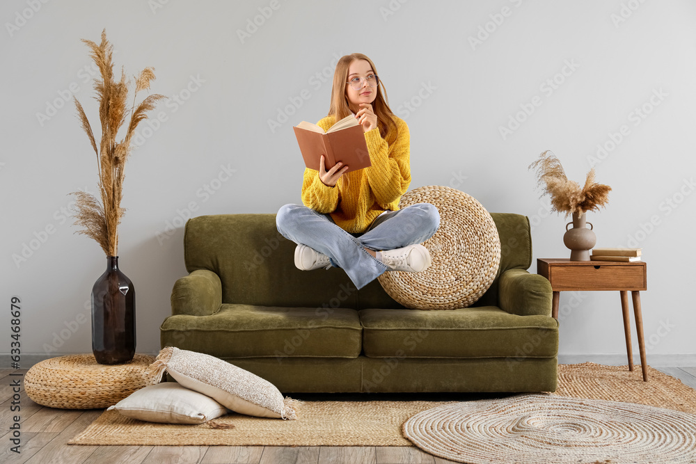 Interior of living room with green sofa and pampas grass in vases