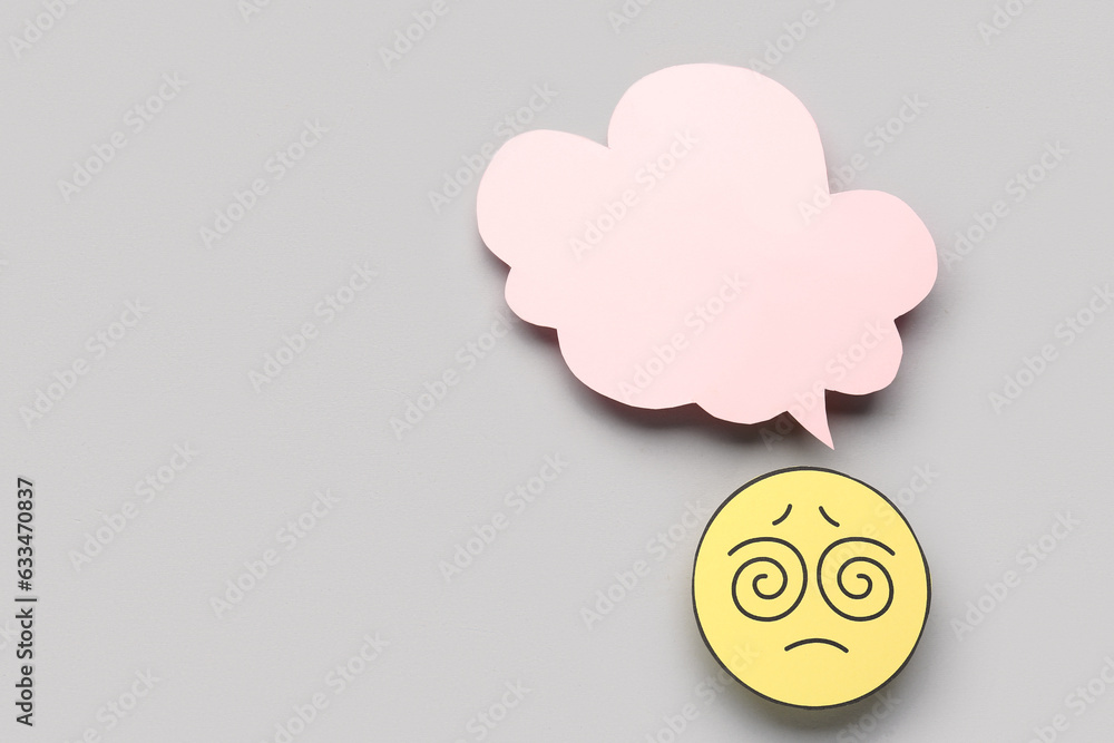 Confused paper face with blank speech bubble on grey background