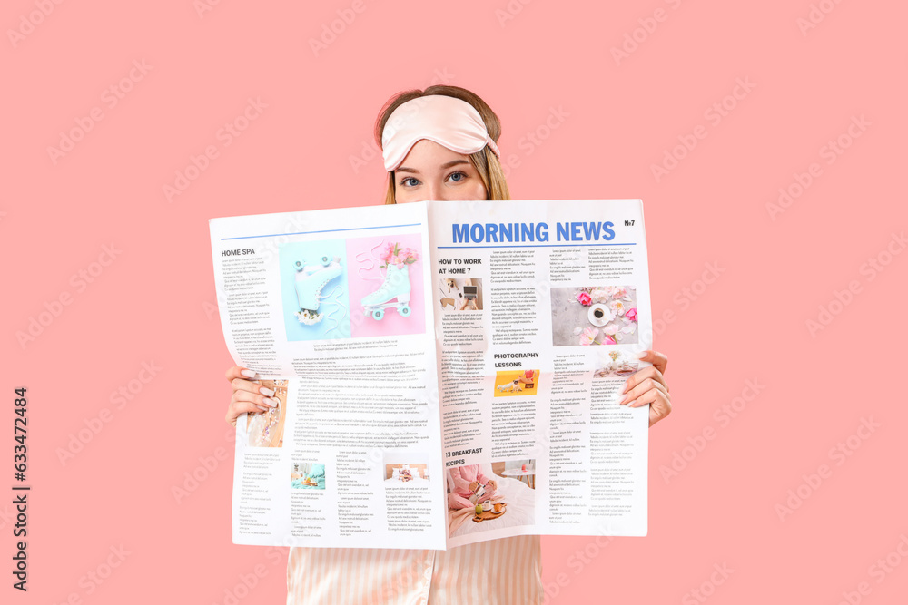 Young woman in pajamas reading morning newspaper on pink background