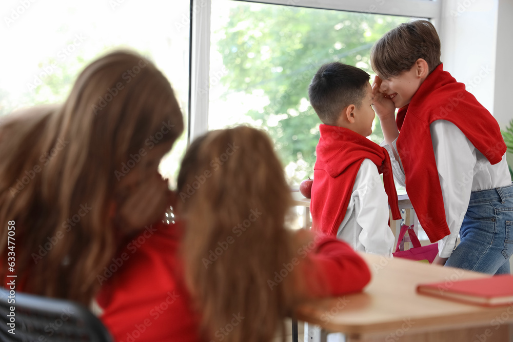 Little boys gossiping in classroom