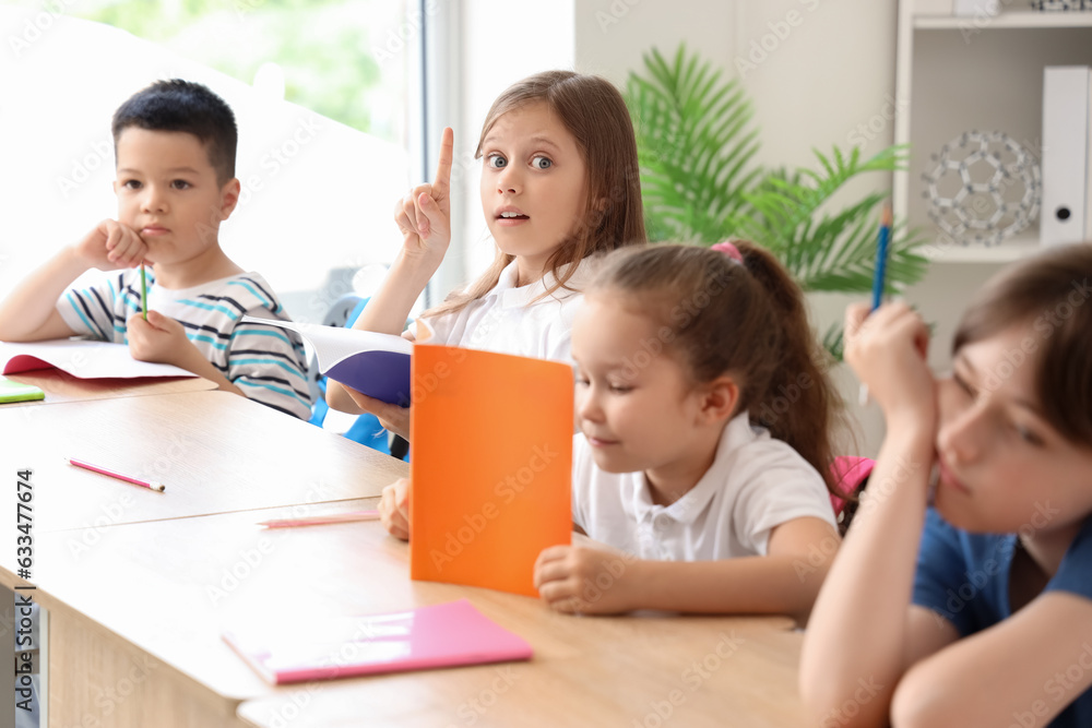 Little pupils having lesson in classroom