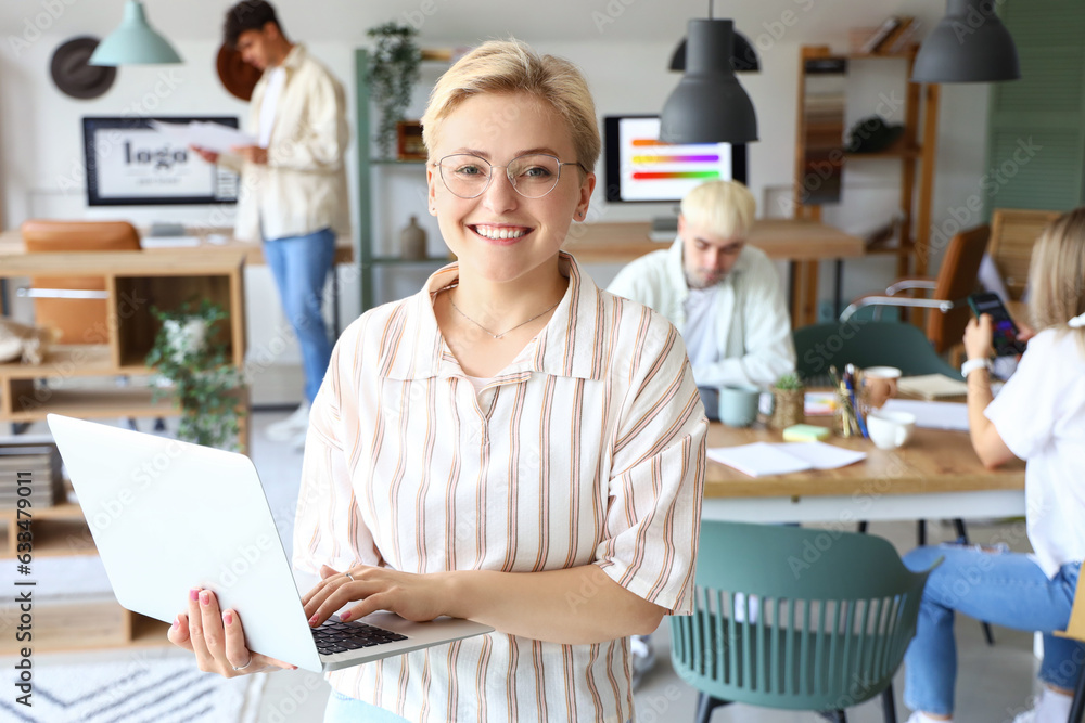 Female graphic designer working with laptop in office