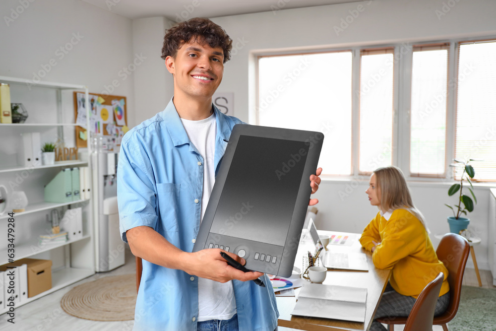 Male graphic designer working with tablet in office