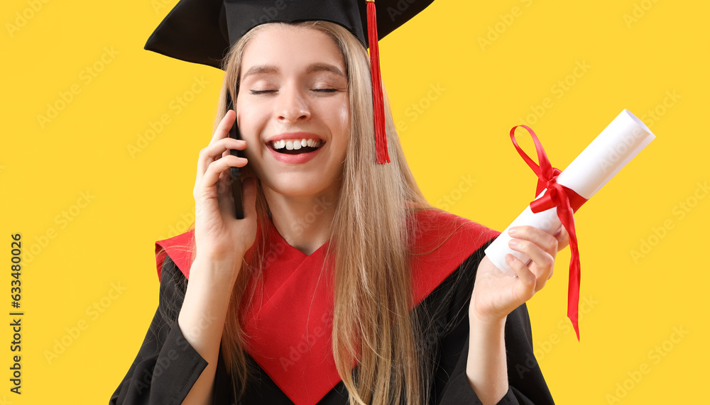 Female graduate student with diploma talking by mobile phone on yellow background