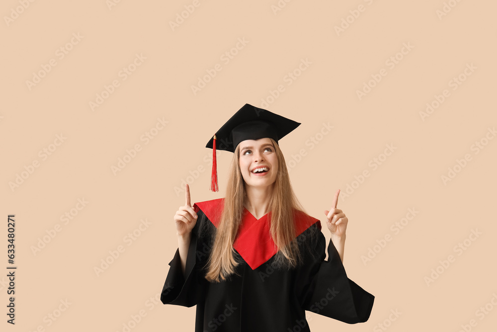 Female graduate student pointing at something on beige background