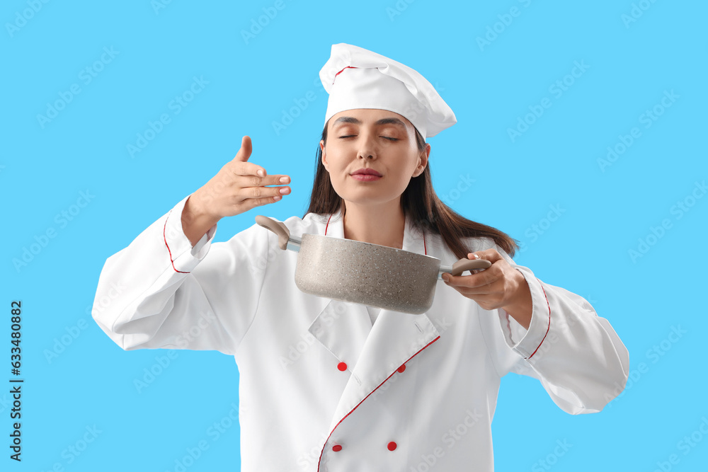 Female chef with cooking pot on blue background