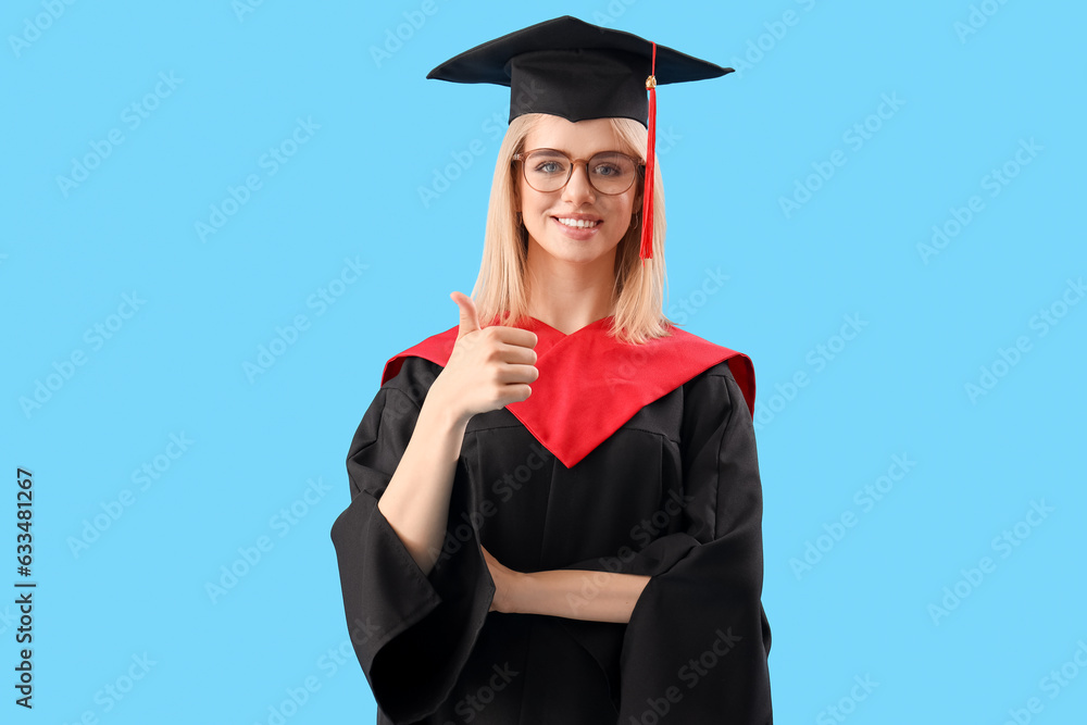 Female graduate student showing thumb-up on blue background