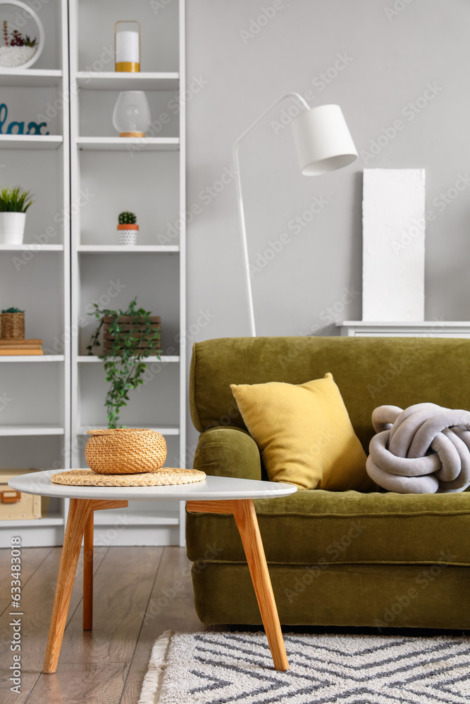 Interior of living room with cozy green sofa and coffee table