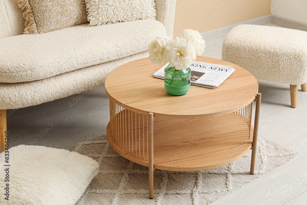 Wooden coffee table with vase of flowers in living room