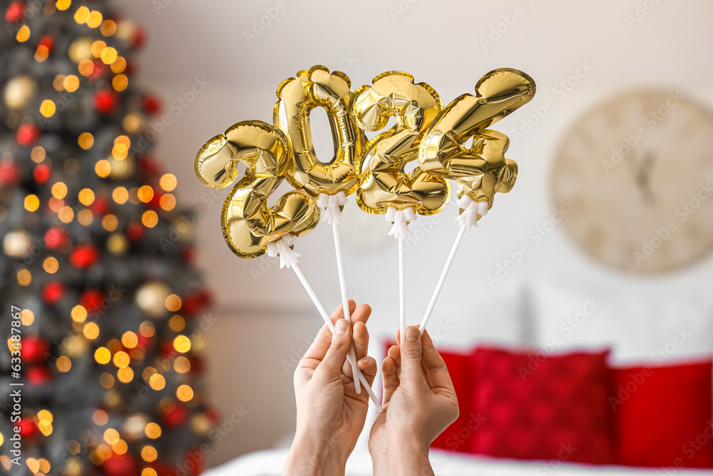 Woman holding balloons in shape of figure 2024 at home, closeup