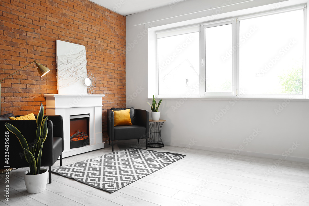 Interior of modern living room with stylish fireplace and armchairs