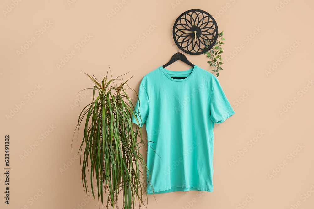 Stylish blue t-shirt hanging on beige background