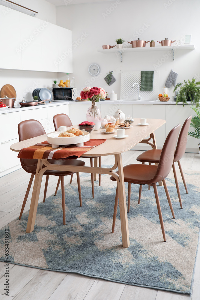 Served dining table on stylish carpet in modern kitchen