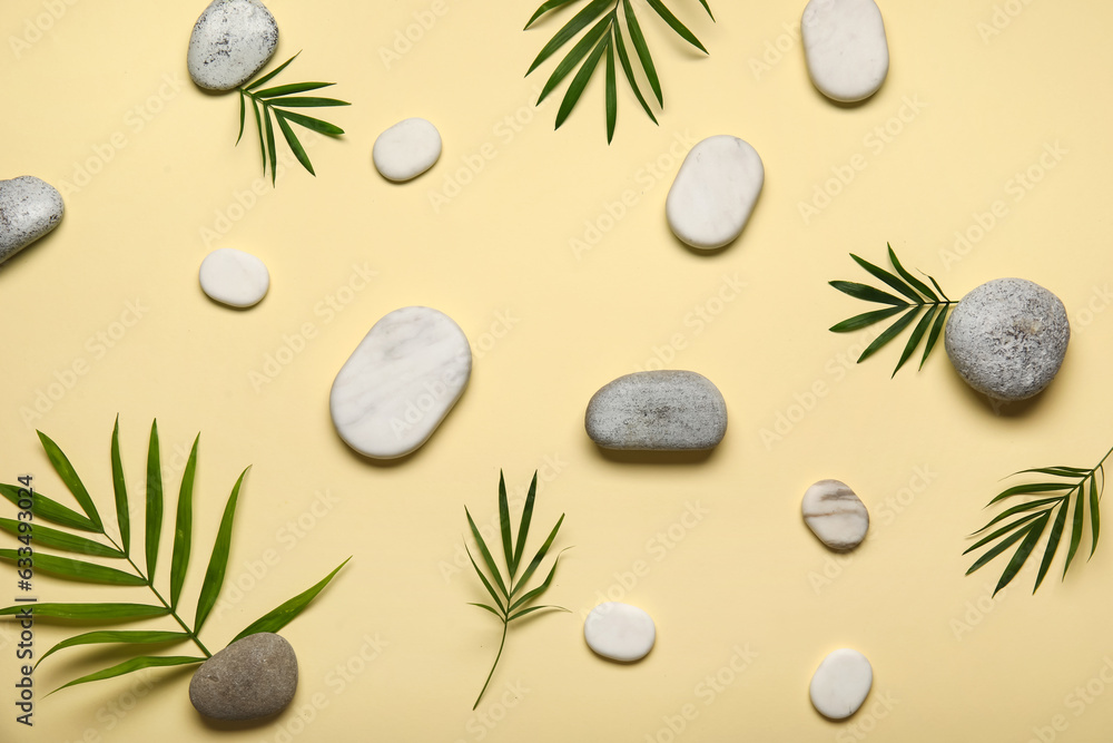 Composition with spa stones and palm leaves on color background