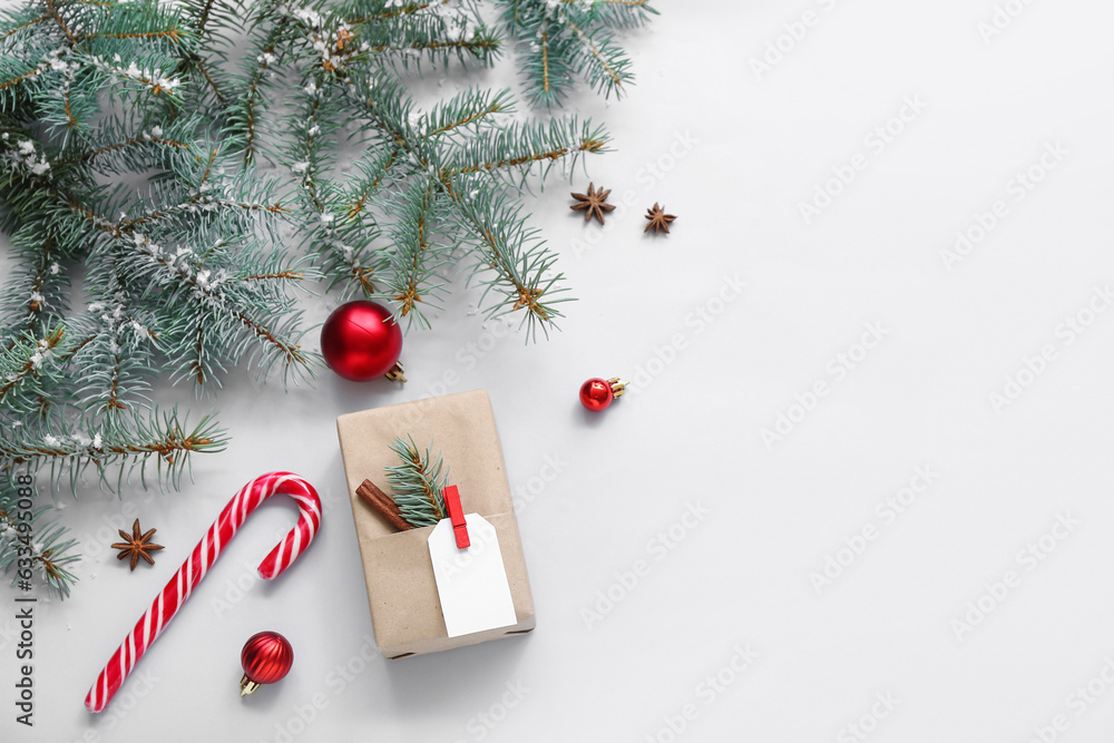 Christmas tree branches with gift box and candy cane on blue background