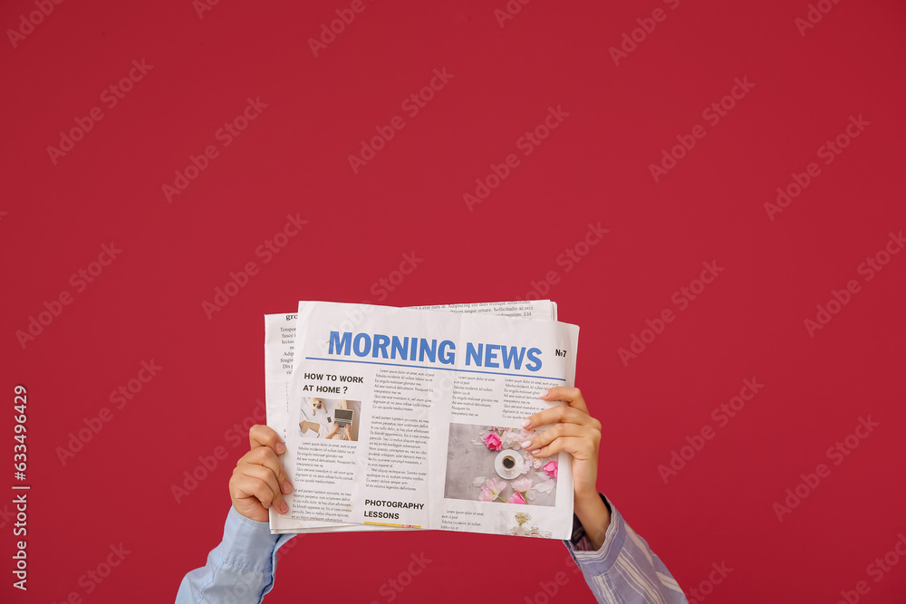 Female hands with newspapers against color background