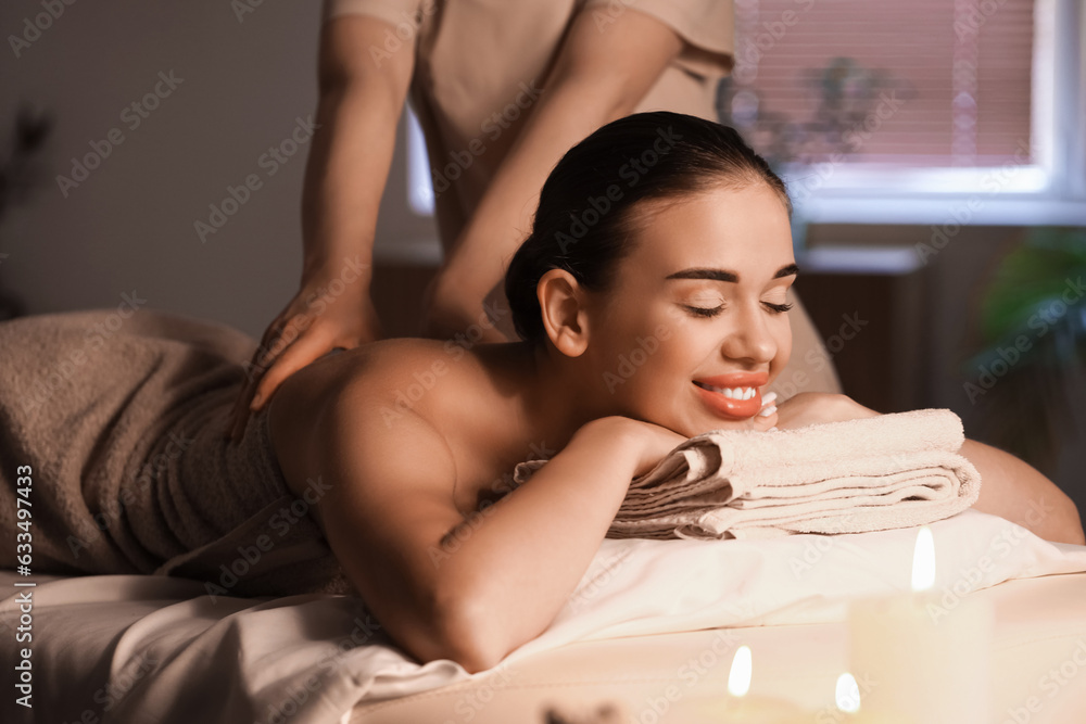 Pretty young woman having massage in spa salon