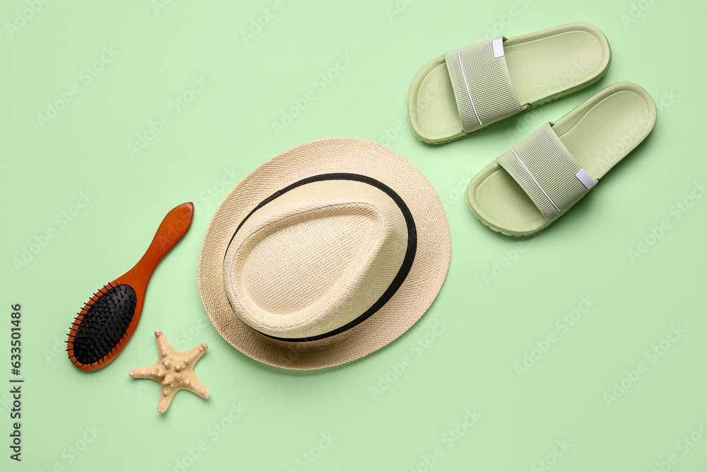 Stylish hat, flip-flops and hair brush on color background