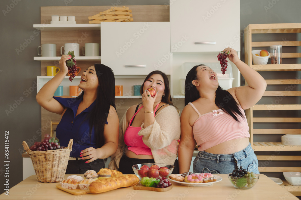 A group of chubby women gather together to cook and eat happily.