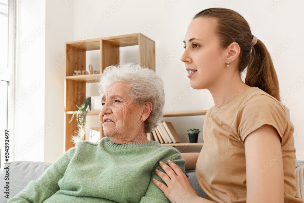 Senior woman with her granddaughter sitting at home