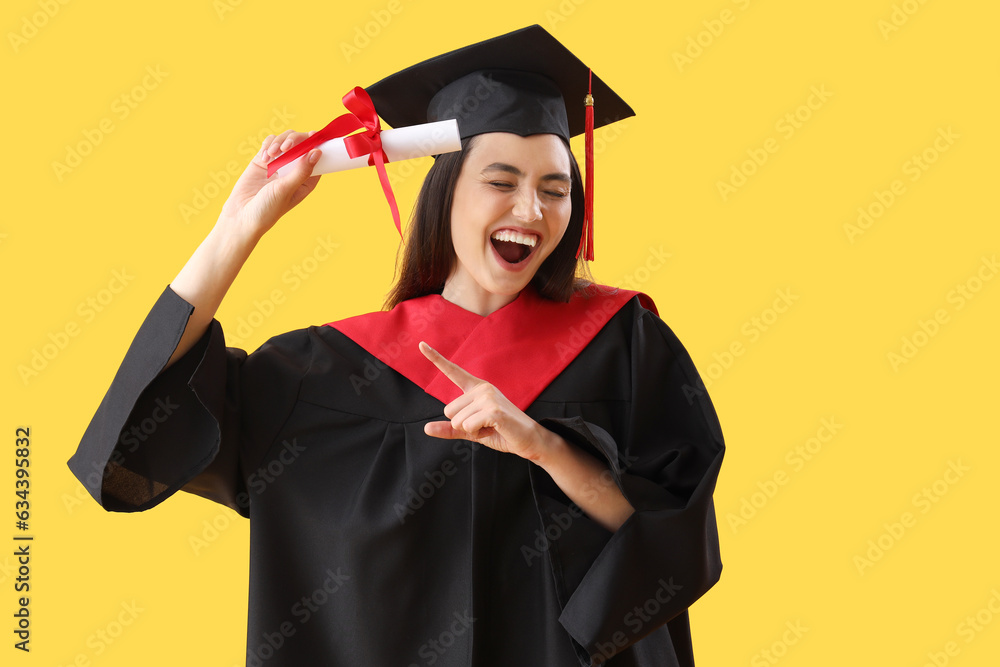 Female graduate student with diploma on yellow background