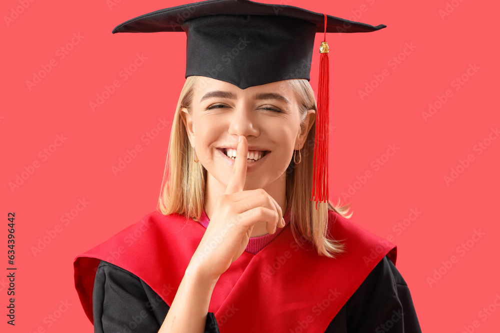 Female graduate student showing silence gesture on red background, closeup