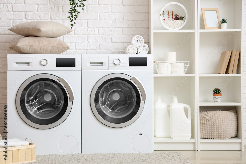 Interior of laundry room with washing machines and shelving unit