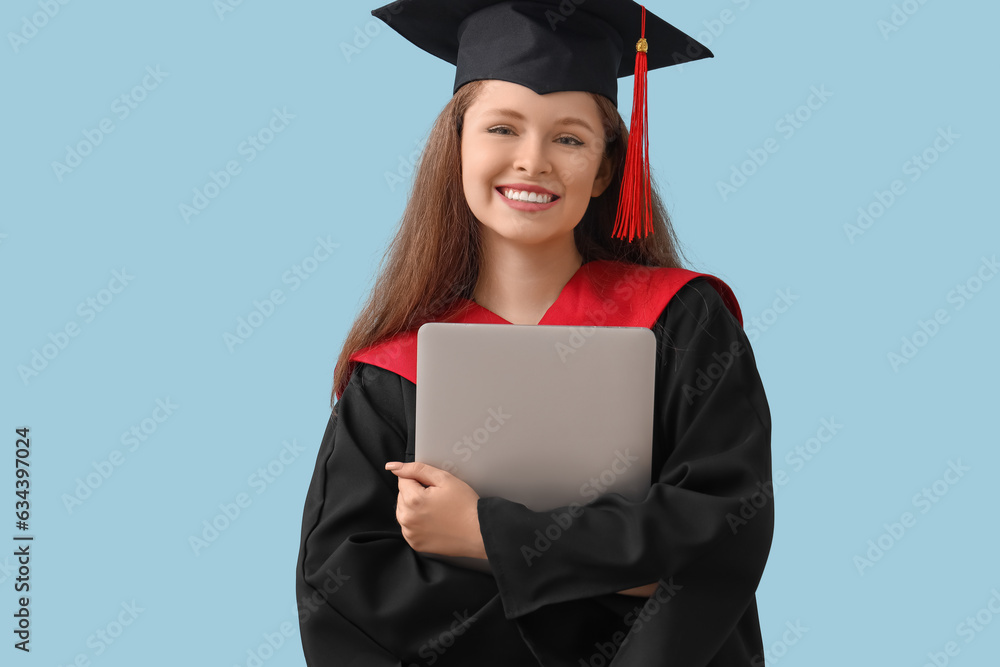 Female graduate student with laptop on blue background