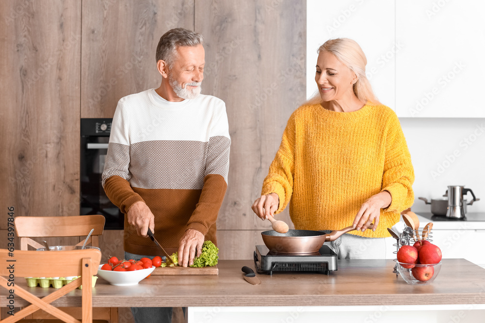 Mature couple cooking in kitchen