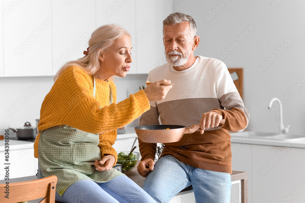 Mature couple eating in kitchen