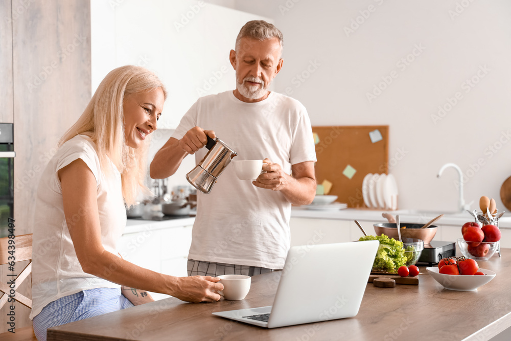 Mature couple drinking coffee in kitchen