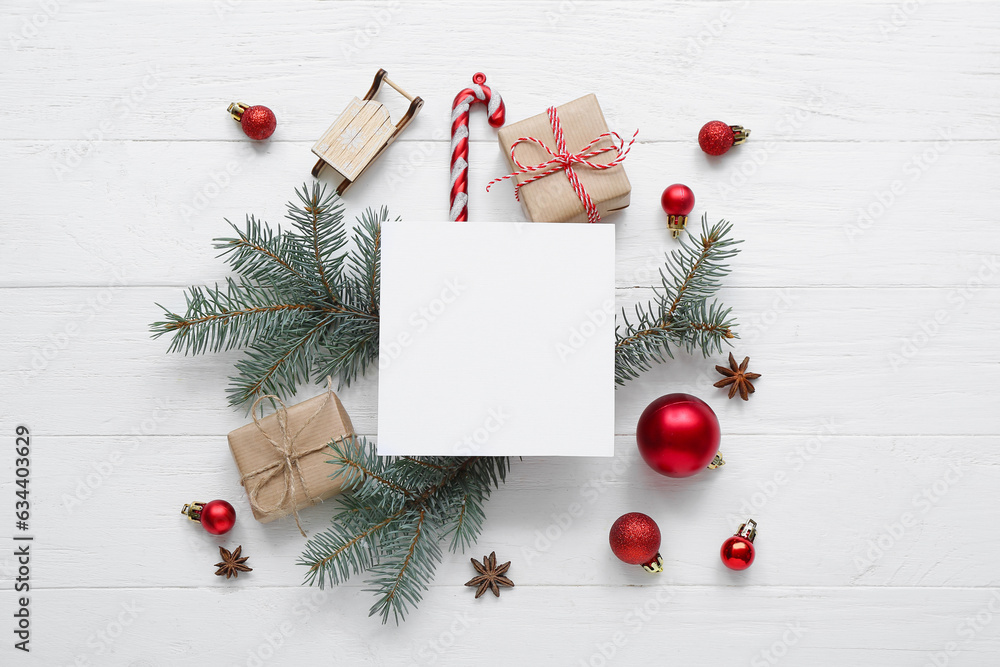 Blank card with Christmas tree branches and gift boxes on white wooden background