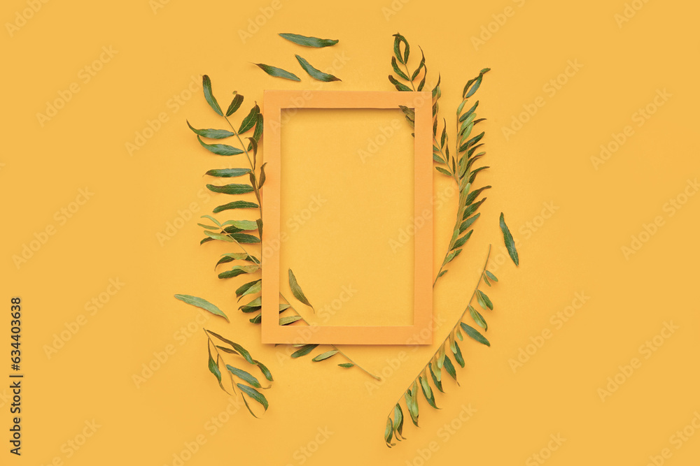 Composition with picture frame and plant leaves on color background