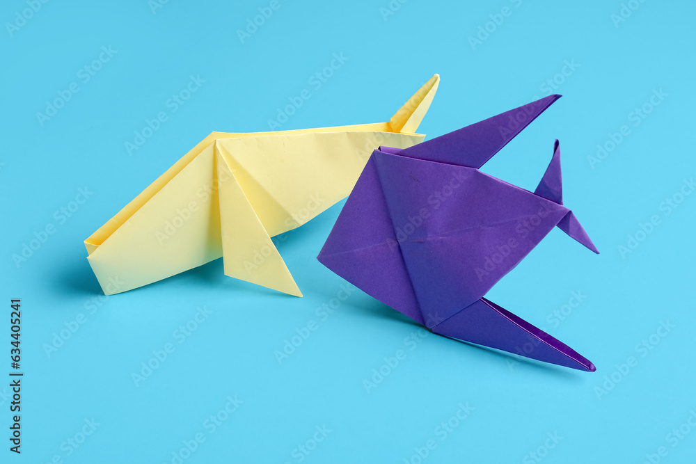 Origami whale and fish on blue background