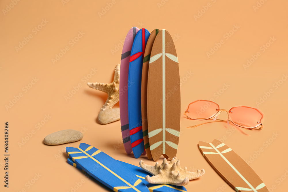 Different mini surfboards, sunglasses and starfishes on yellow background